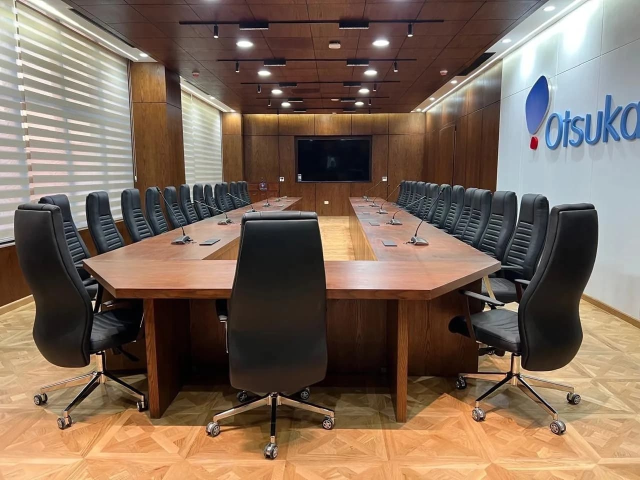 Modern conference room with black chairs and wooden table.